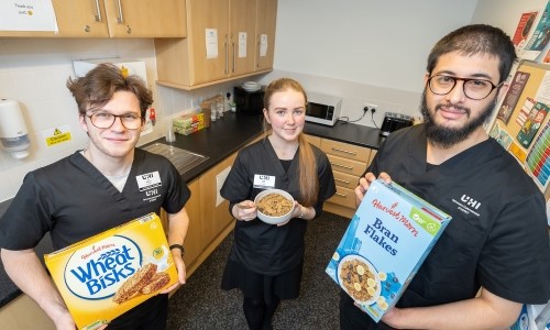 Left to right: Optometry students Leo Huisman, Crista Arthur and Suad Badshah holding breakfast supplies in the student kitchen at UHI House